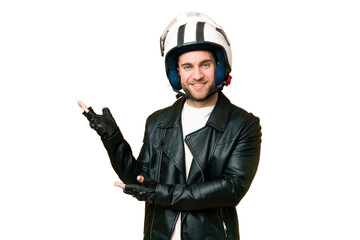 Wall Mural - Young handsome blonde man with a motorcycle helmet over isolated chroma key background extending hands to the side for inviting to come