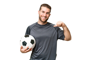 Wall Mural - Young handsome blonde man over isolated chroma key background with soccer ball and proud of himself