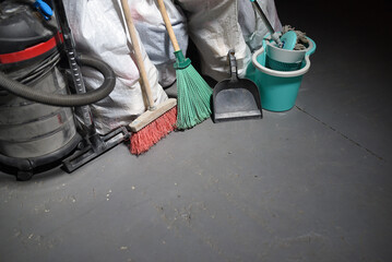 Wall Mural - Broom, dust pan , bucket, mop, vacuum cleaner and trash bags garbage on the dirty dusty floor. Cleaning concept.