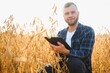 © Serhii - Young agronomist holds tablet touch pad computer in the soy field and examining crops before harvesting. Agribusiness concept. agricultural engineer standing in a soy field with a tablet.