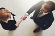 Business, people and handshake above in office for welcome or greeting to career or corporate job, recruitment and hiring. Man, woman and shaking hands for agreement or proposal for b2b and top view.