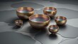 Elegant Metal Singing Bowls on Textured Gray Surface in Serene Arrangement.