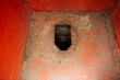 Photo of a hole in an old smelly dirty metal rusty rural toilet in Russia.