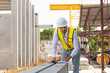© JU.STOCKER - Engineer man checking project at the precast factory site, Foreman worker in hardhat on construction site