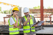 © JU.STOCKER - Engineer and female foreman worker team checking project at precast factory site, Engineer and builders in hardhats discussing on construction site