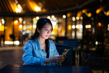 Wall Mural - Woman use of mobile phone at outdoor in the evening time