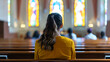 © RISHAD - Woman dressed in yellow sits alone in church pews, her back to the camera, in a quiet, reflective moment within a brightly lit church.
