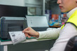 © suwanb - Beautiful Asian woman uses a laptop or notebook to print bar code stickers on a bar code printer. Selective focus at sticker barcode.