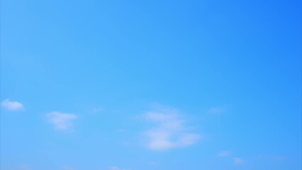Wall Mural - Rapidly moving clouds paint a dynamic scene against a clear blue backdrop in this stunning time-lapse. Meteorology and Water cycle concept. High-quality video. Time lapse. Blue sky background. 4K.
