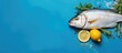 A top view of a delicious fresh dorado fish beautifully presented on a blue background with slices of lemon sprigs of rosemary and various spices The image also includes ample copy space