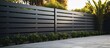 © StockKing - A sleek and contemporary metal fence with horizontal sections made of steel grating designed to enclose the yard area Perfect for a modern aesthetic Copy space image