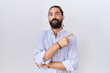 © Krakenimages.com - Hispanic man with beard wearing casual shirt pointing with hand finger to the side showing advertisement, serious and calm face