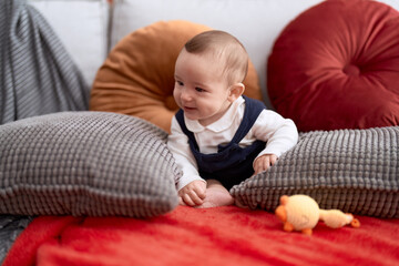 Sticker - Adorable toddler smiling confident sitting on sofa at home