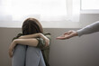 © fizkes - Adult woman giving helping hand to crying teenager girl, victim of bullying, abuse, violence, depressed patient, offering psychotherapy, support to lonely sad child sitting on floor