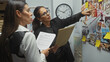 © Krakenimages.com - Two women detectives analyze evidence on a bulletin board in a police department's investigation room.