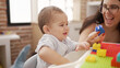 © Krakenimages.com - Teacher and preschool student playing with construction blocks sitting on table at kindergarten
