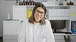 © Krakenimages.com - Smiling young hispanic woman medical researcher wearing glasses in laboratory, portrait