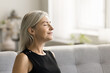 © fizkes - Happy relaxed mature woman enjoying fresh air, smells, relaxation, leisure at home, taking deep breath with closed eyes, smiling, meditating, reloading mind, enjoying stress relief technique