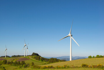 fields of wind turbines on the french hills in the herault on a blue sky background.