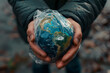 Hands holding planet earth wrapped in plastic. The concept plastic pollution of the Earth.
