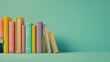 © Nico - A row of books with a green background. The books are of different colors and sizes with copy space