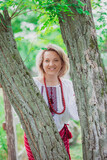 Fototapeta  - beautiful peasant woman in embroidered Ukrainian clothes in the garden