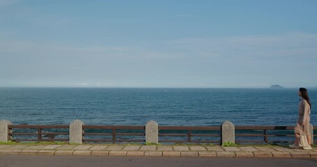 Poster - Woman walk along the seaside waterfront