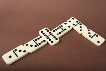 Wall Mural - Dominoes on a brown background. White