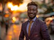 Smiling Young Black Man in Stylish Suit at Sunset on City Street
