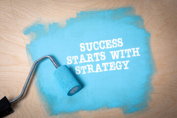 Wall Mural - success starts with strategy. blue paint and paint roller on plywood background