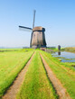 View of an old windmill, Holland. The road leading to the windmill. Agriculture. Historical buildings. View of landscapes in the Netherlands. Nature in the morning.