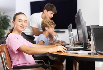 Wall Mural - Portrait of female schoolgirl at computers in shool computer class