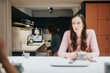 © qunica.com - Casual lifestyle scene with two women in a modern kitchen sharing a relaxed moment.