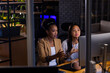 © Wavebreak Media - At office, diverse female business colleagues discussing over computer, working late