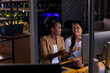 © Wavebreak Media - At office, diverse female business colleagues discussing, working late