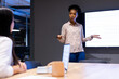 © Wavebreak Media - At office, diverse female colleagues discussing near sales tracker, working late