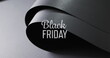 Image of black friday text over rolled up black paper on grey background