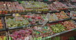 Image of numbers changing and moving over fresh fruits in crates arranged in supermarket