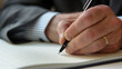 © Ali - close up of hand writing in notebook, businessman writing business ideas or future plans, important tasks for today