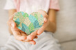 Hands holding heart shape in green leaves pattern, world environment day, earth day, CSR, ESG, sustainable living concept
