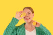 smiling curvy woman  covering eye with piece of orange on yellow background. concept of diet and healthy lifestyle	