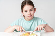 A cute little girl is having breakfast. A healthy breakfast of eggs, toast, cottage cheese and cucumber on her plate. Close-up. Selected focus