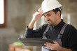 Disappointed construction worker checking tablet