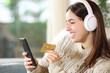 Happy woman with headphone buying media online