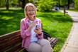 Portrait of happy mature woman in park. She is enjoying sunny day in park.