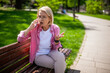 Portrait of mature woman in park. She is talking on phone.