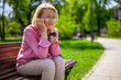 Portrait of mature woman in park. She is worried and depressed.