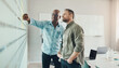 © Flamingo Images - Focused diverse businessmen using adhesive notes during a brainstorming session at work