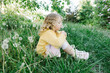© Westend61 - Blond curly haired girl smelling dandelion flower in meadow