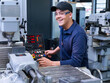 © Westend61 - Happy apprentice operating CNC machine at factory